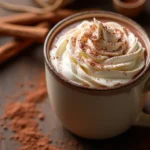 What Are the Benefits of Bone Broth Hot Chocolate: A mug of bone broth hot chocolate topped with whipped cream and a dusting of cacao powder, served on a rustic wooden table.