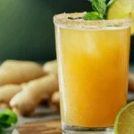 Ginger Beer Mocktail % A glass of ginger beer mocktail garnished with lime slices and mint sprigs